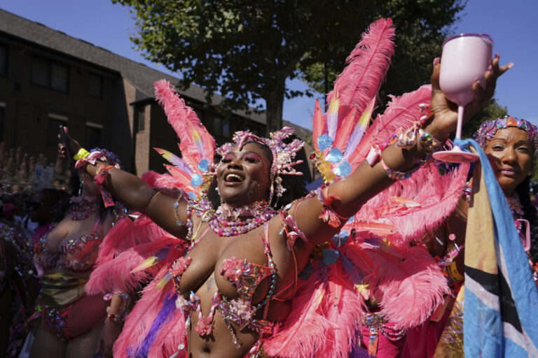 Top foto dňa (25. august 2025): Karneval Notting Hill, požiar, vystúpenie pred turné Oasis, socha Germanie, fotoaparát novinárky